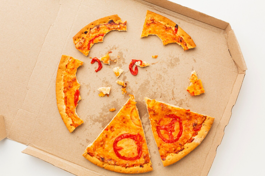 Half-eaten pizza on greasy box