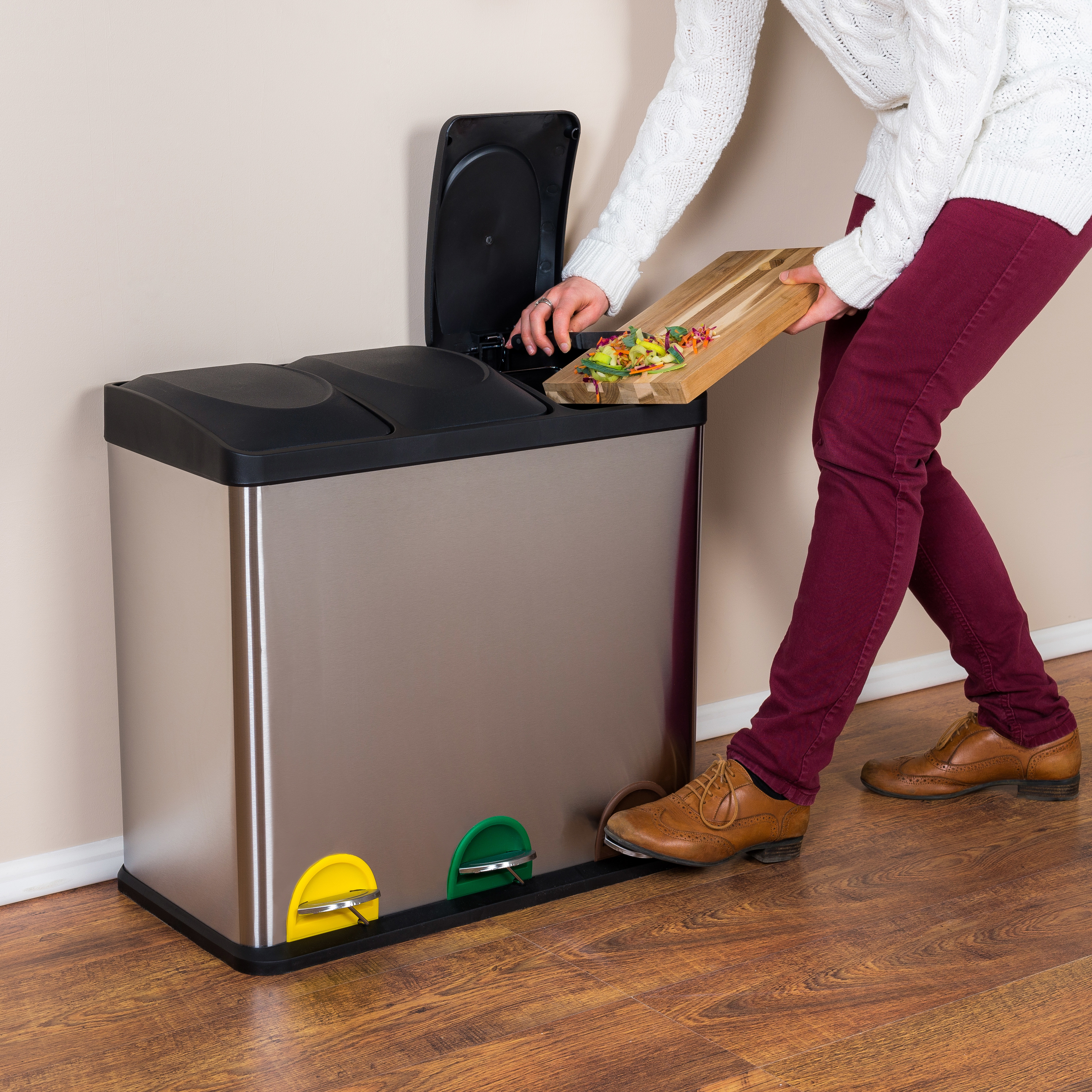 woman throwing wasted food into steel bin