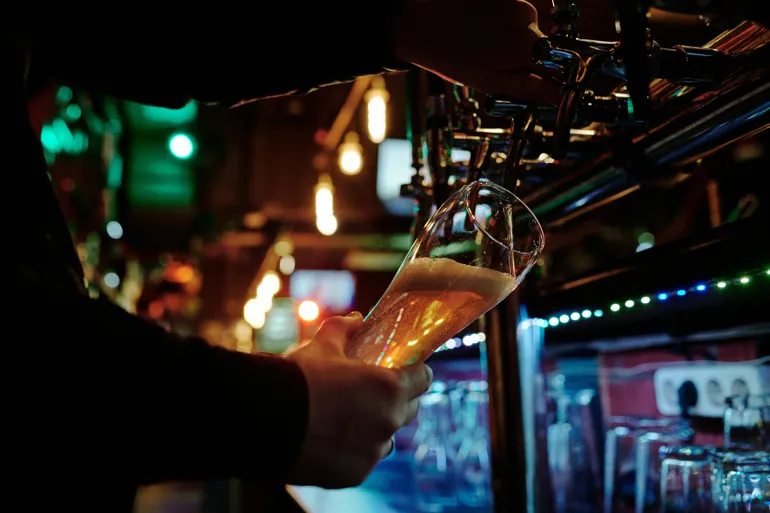 Beer being poured behind bar