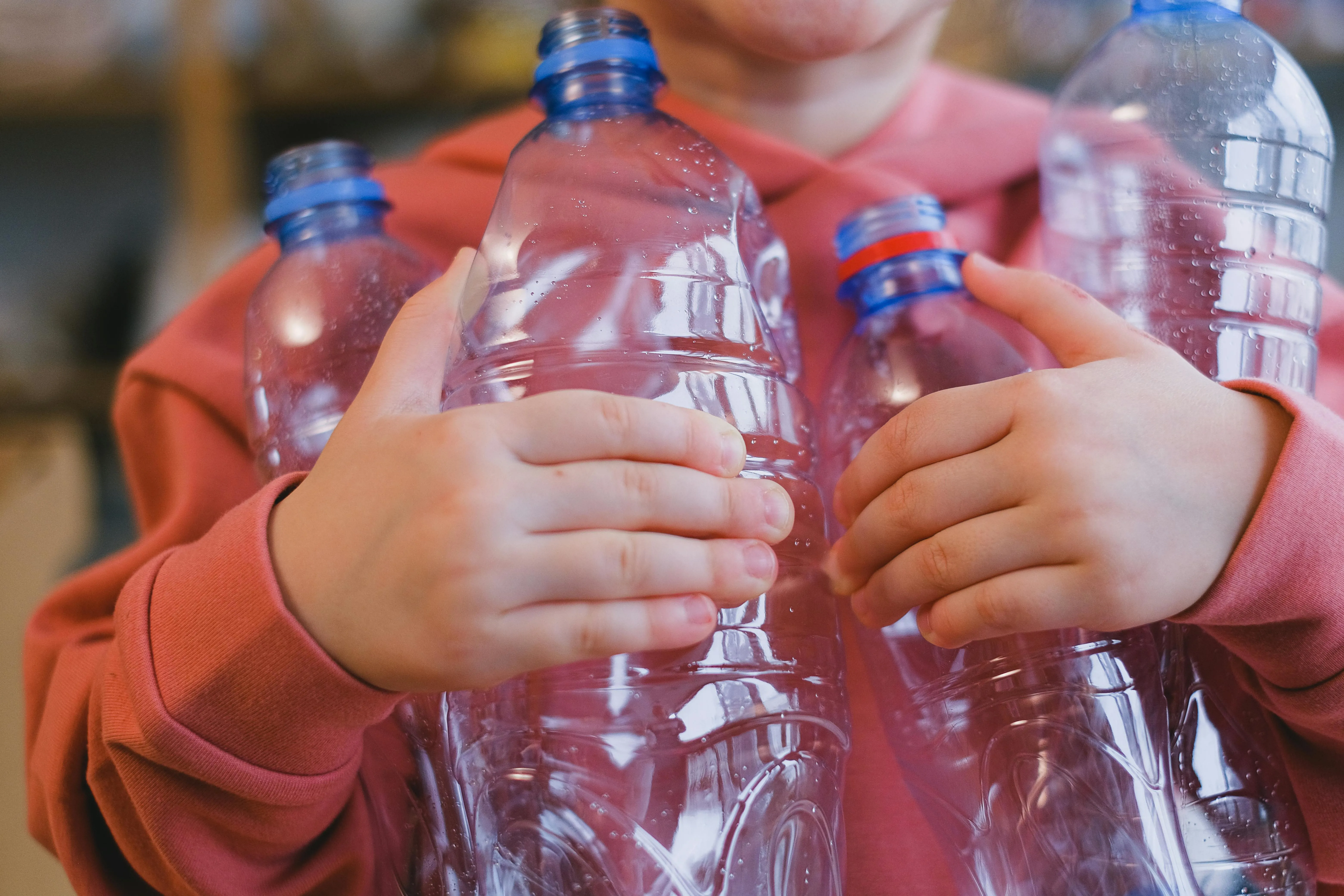 child holding plastic bottles