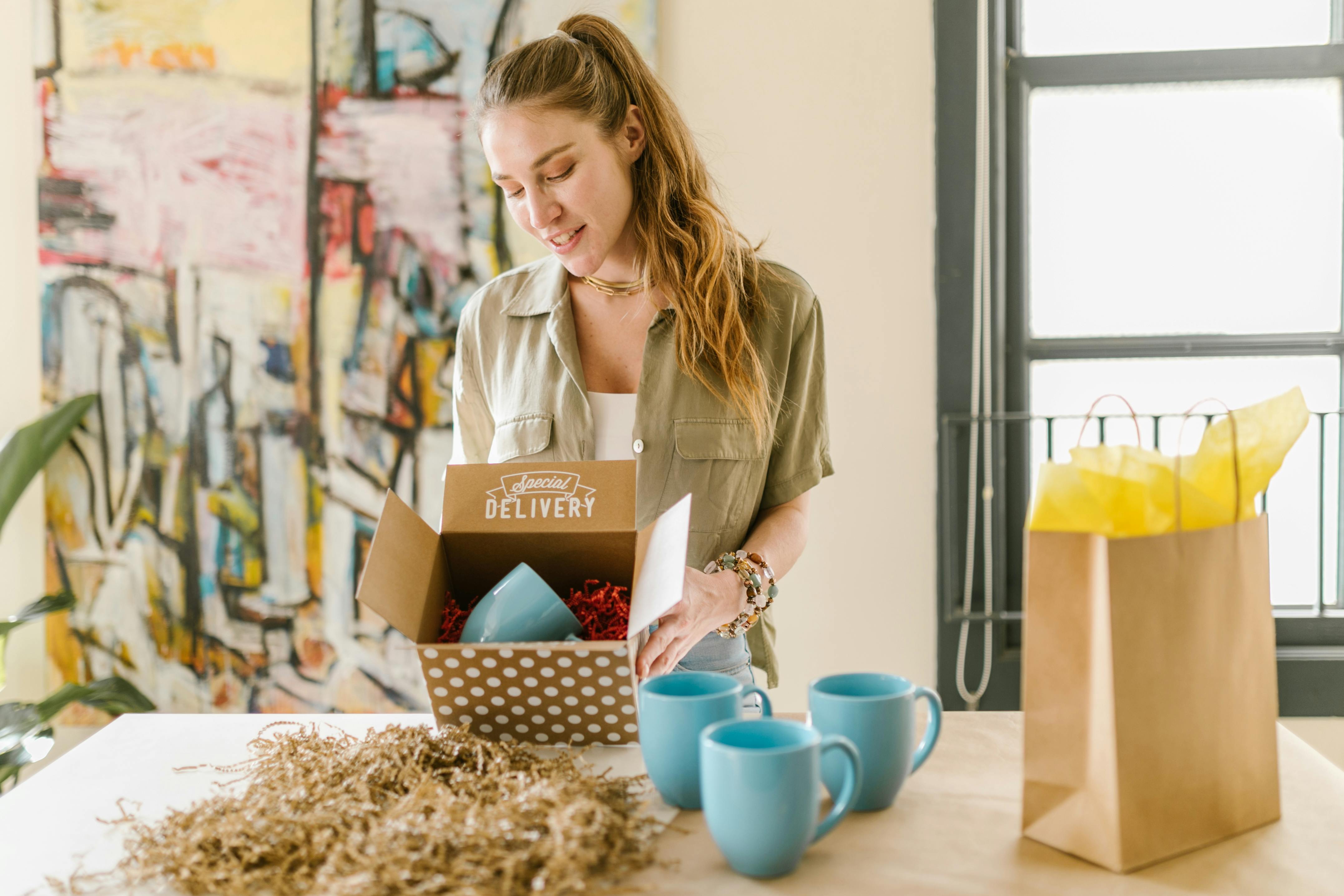 woman holding cardboard box with a mug