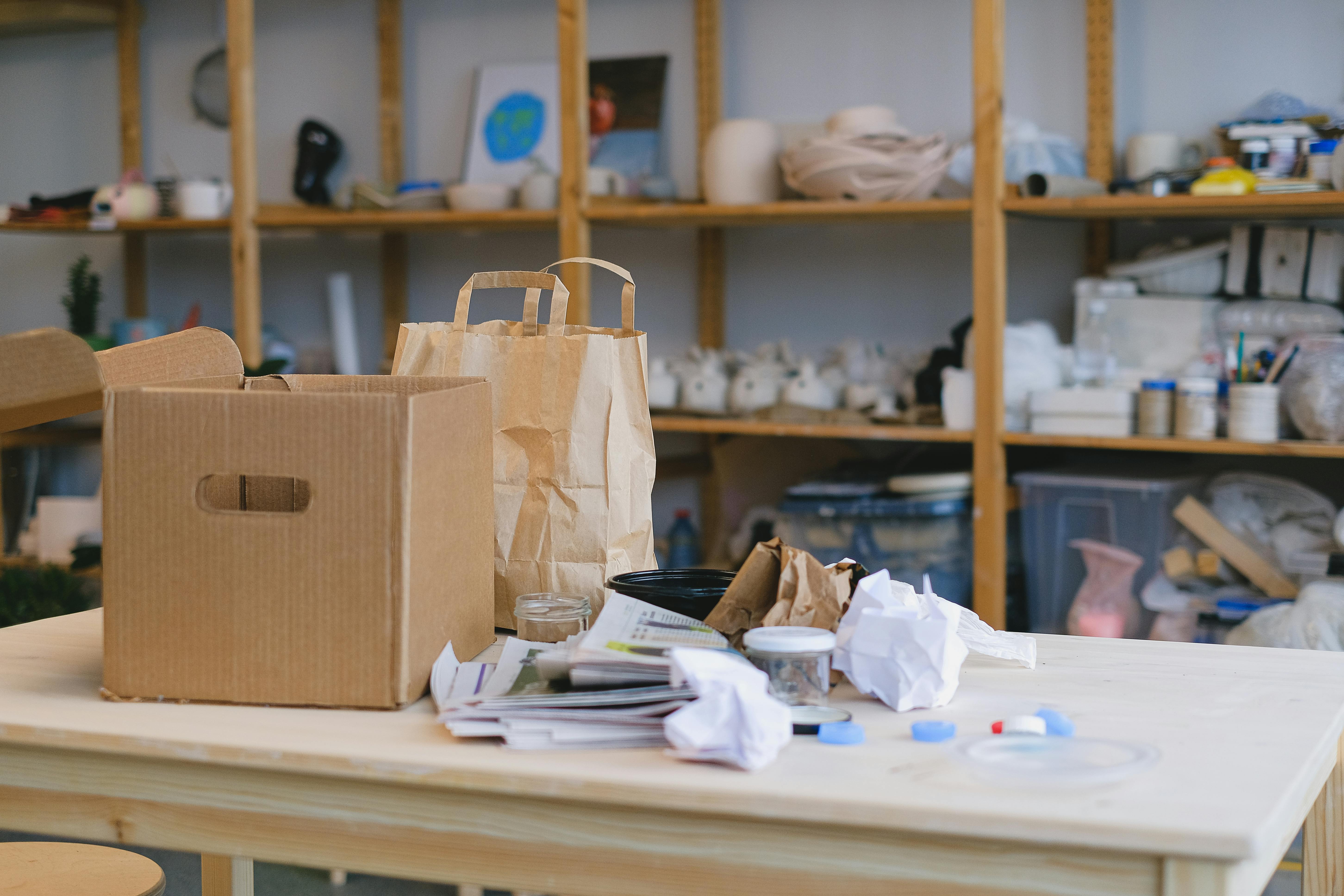 cardboard box, paper bag and paper on table in store room