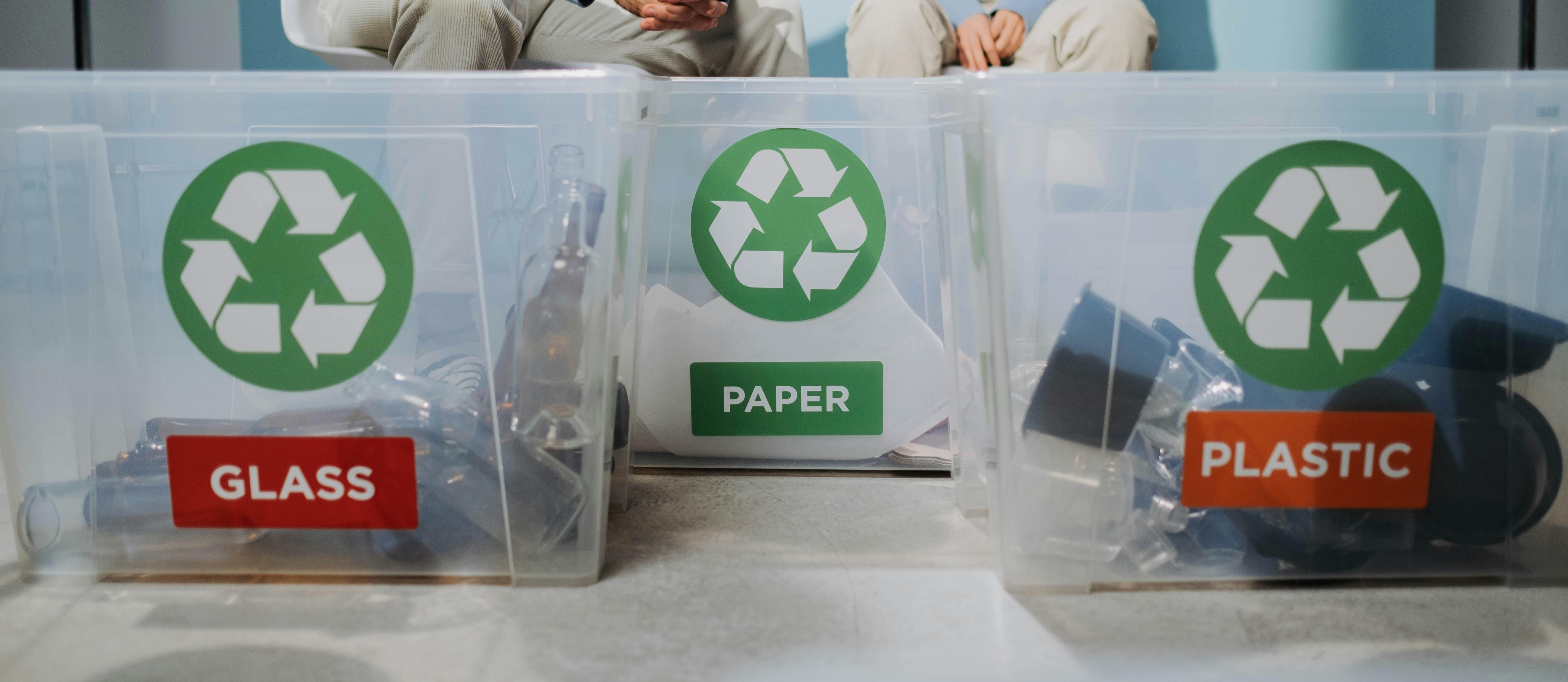 recycling waste being sorted into separate boxes for glass paper and plastic