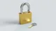 Closed gold padlock with silver key