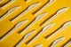 Single-use plastic knives arranged on a yellow background